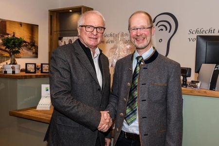 Herr Günter Neuser schüttelt einem anderen Herrn die Hand in seinem Geschäft
