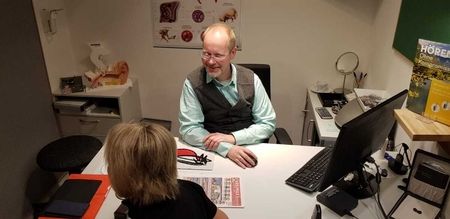 Herr Günter Neuser berät eine Kundin in seinem Hörcentrum