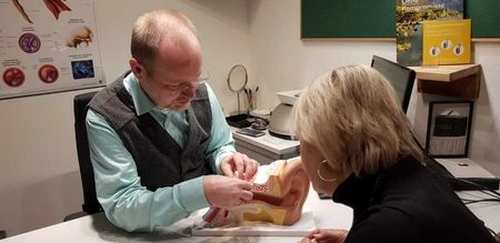 Herr Günter Neuser berät eine Kundin in seinem Hörcentrum