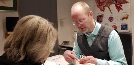 Herr Günter Neuser berät eine Kundin in seinem Hörcentrum