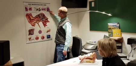 Herr Günter Neuser berät eine Kundin in seinem Hörcentrum
