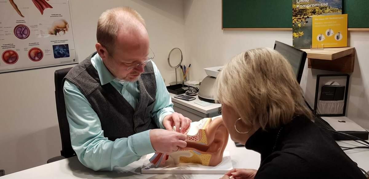 Herr Günter Neuser berät eine Kundin in seinem Hörcentrum